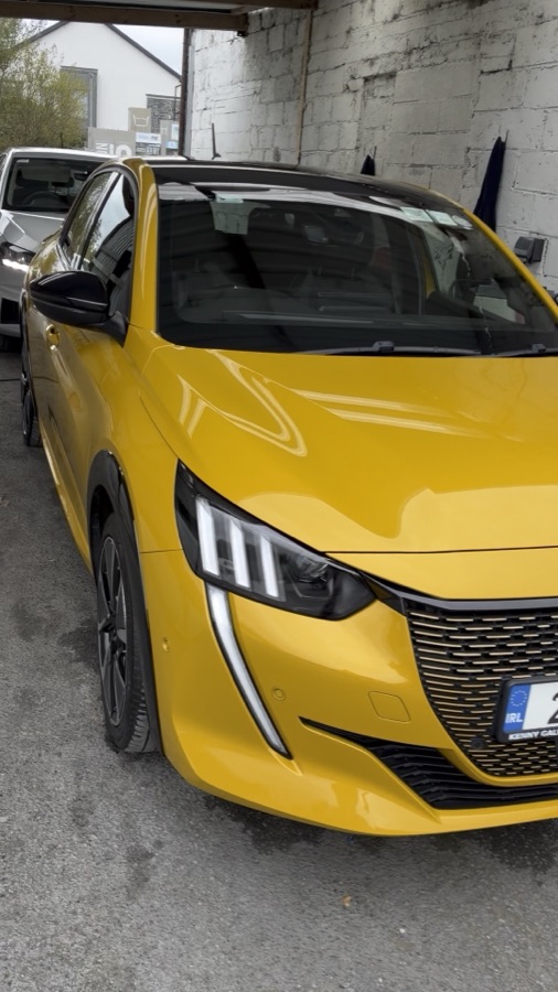 A freshly washed yellow Peugeot at the wash