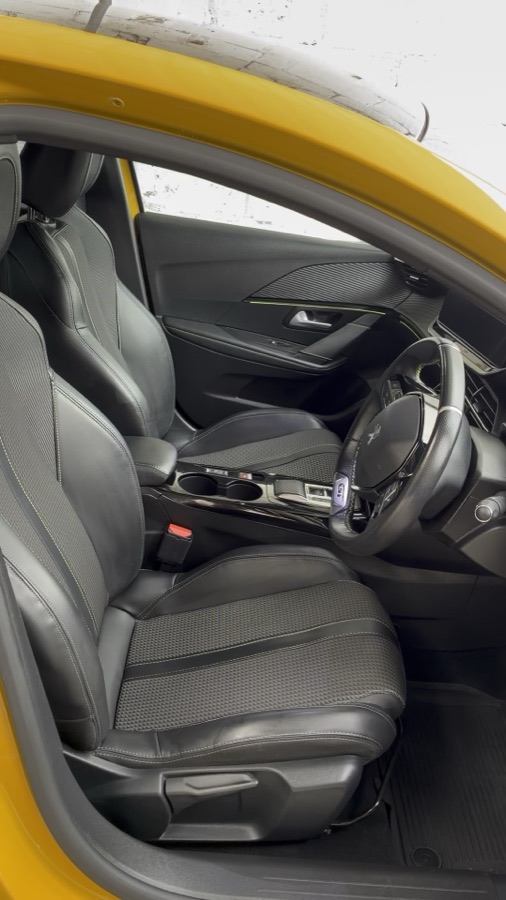 Clean front seats and dashboard of a valeted yellow Peugeot